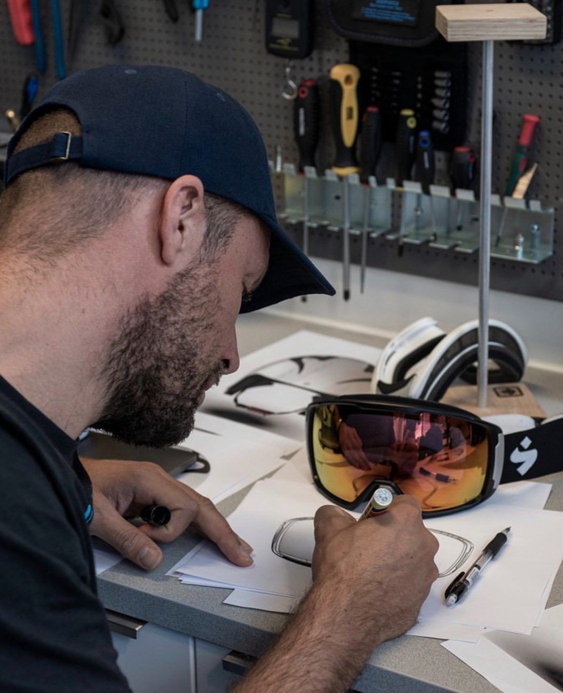 A designer sketching a goggle at the workbench