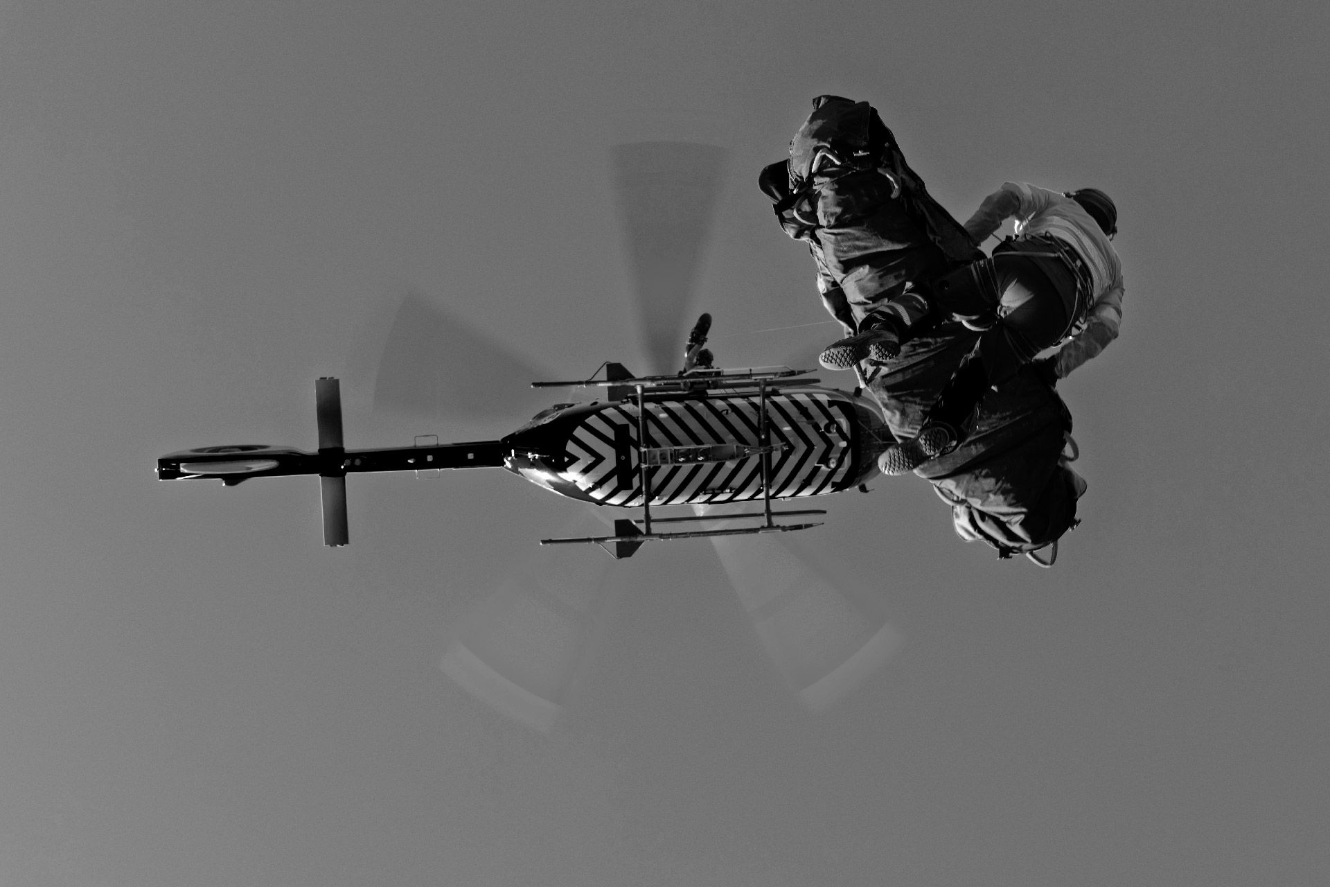 Rescuer on a hoist line beneath a helicopter